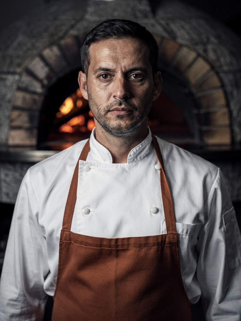Executive Chef Lorenzo Romano preparing signature dishes over wood-fired grill