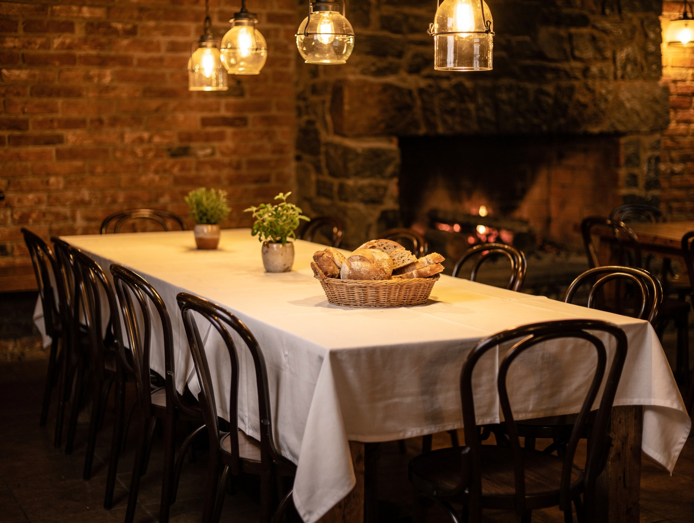 Grand wood-fired hearth dining room with warm candlelit tables